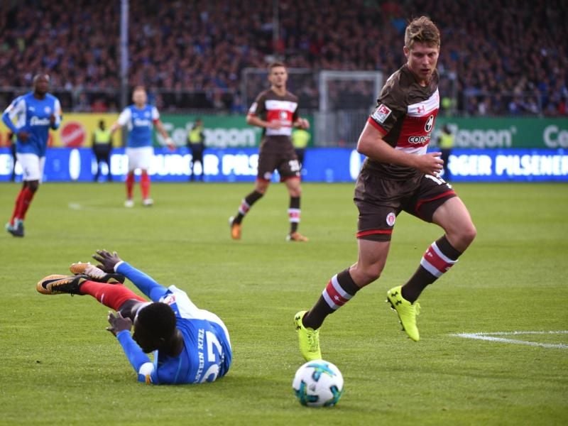 Daniel Buballa (r) kann sich gegen den Kieler Kingsley Schindler durchsetzen, der beim Zweikampf um den Ball stürzt. Foto: Axel Heimken