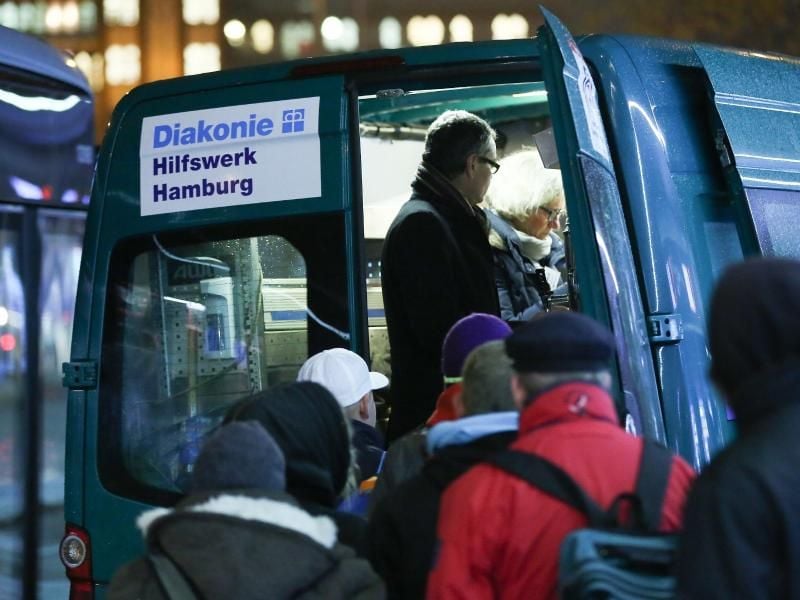 Bedürftige stehen am Mitternachtsbus der Diakonie Hamburg. Foto: Bodo Marks/Archiv