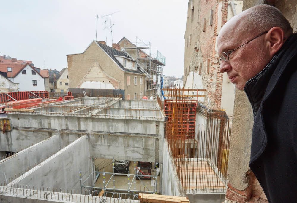 BWG-Geschäftsführer Holger Köhncke lässt seinen Blick über die Baustelle am Saalplatz schweifen. Bis auf das ehemalige Handelshaus sollen Ende 2017 alle Gebäude bezugsfertig sein.