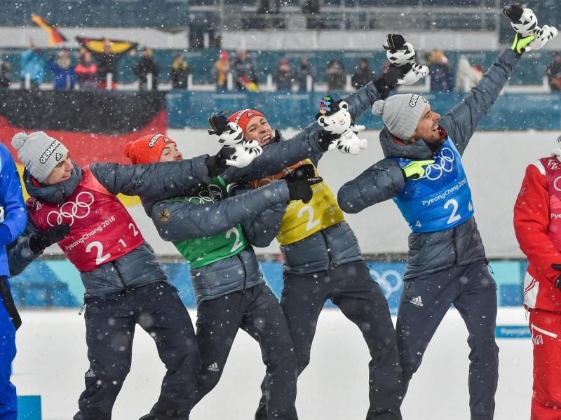 Vinzenz Geiger (l-r) Fabian Rießle, Eric Frenzel und Johannes Rydzek posieren nach dem Gewinn der Goldmedaille wie Usain Bolt. Foto: Angelika Warmuth