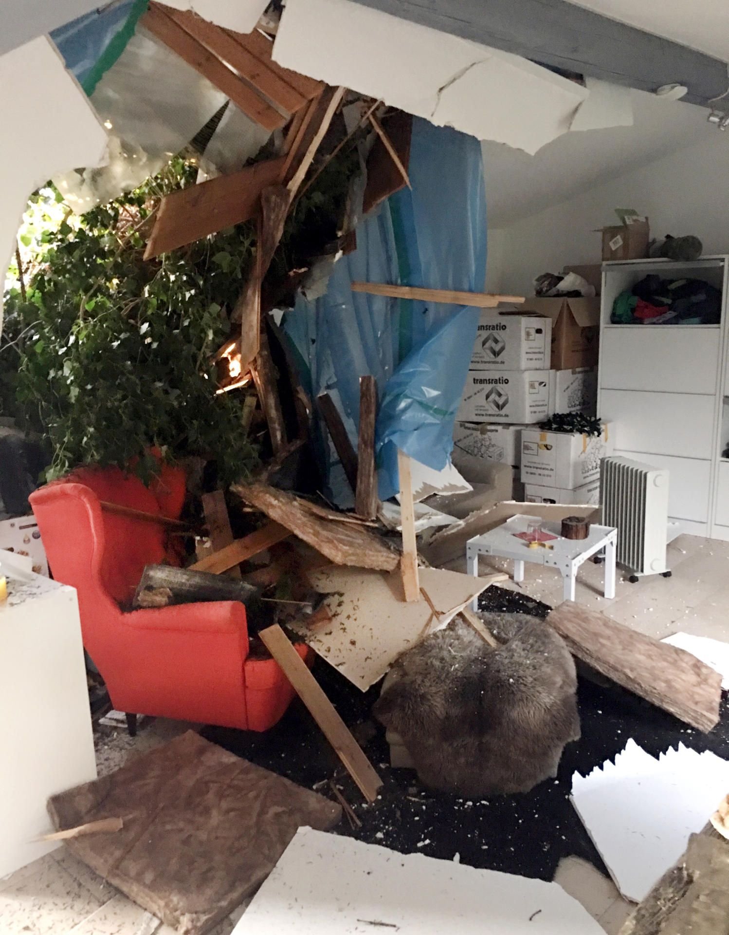 Teile eines umgestürzter Baum liegen in einem Haus in Mülheim.