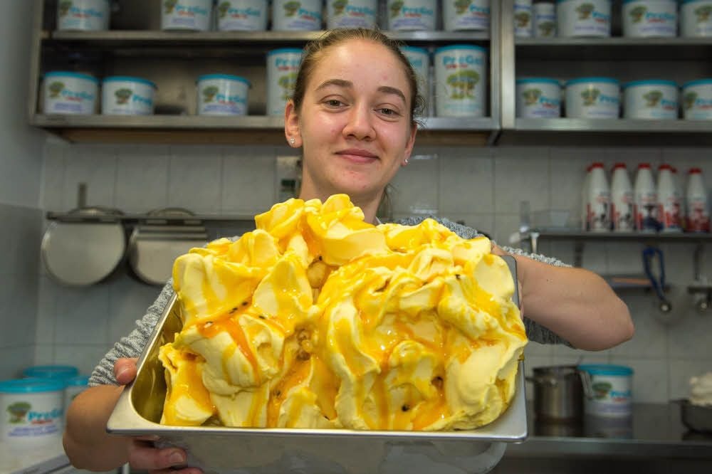 Mehrere Liter Schlemmer-Vergnügen: „Il Gelato“-Mitarbeiterin Roxana hat gerade frisches veganes Mangoeis hergestellt.