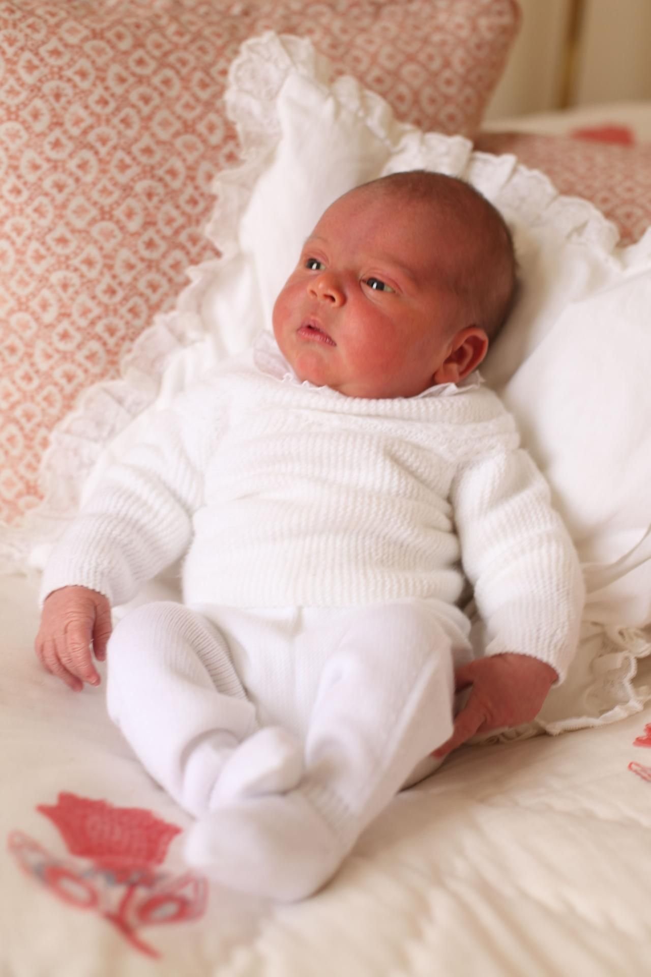 Prinz Louis ganz in Weiß gekleidet auf einem Kissen.