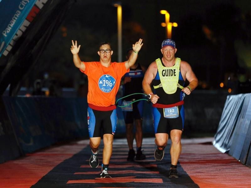 Geschafft Chris Nikoc (l) feiert neben seinem Trainer Dan Grieb seinen Zieleinlauf beim Ironman 2020. Foto: Michael Reaves/Getty Images for IRONMAN/dpa