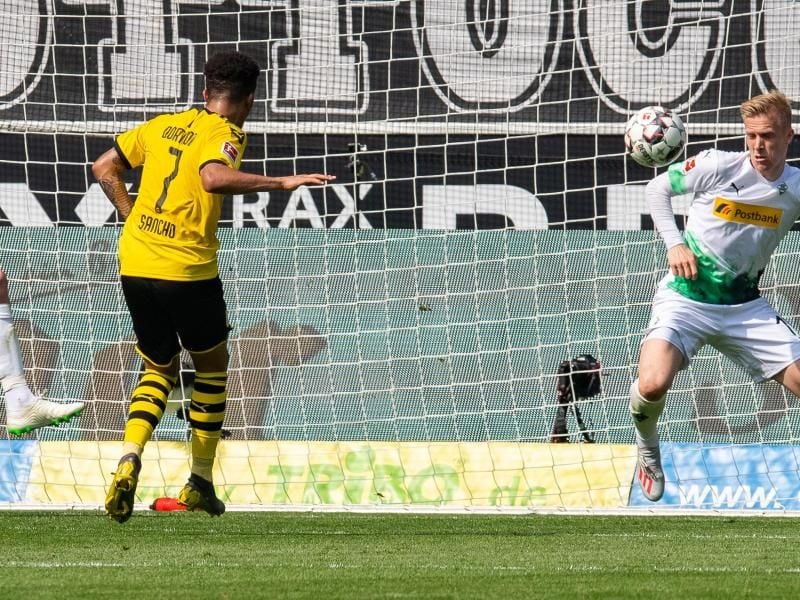 Jadon Sancho (l) trifft zum 1:0 in Gladbach. Foto: Guido Kirchner