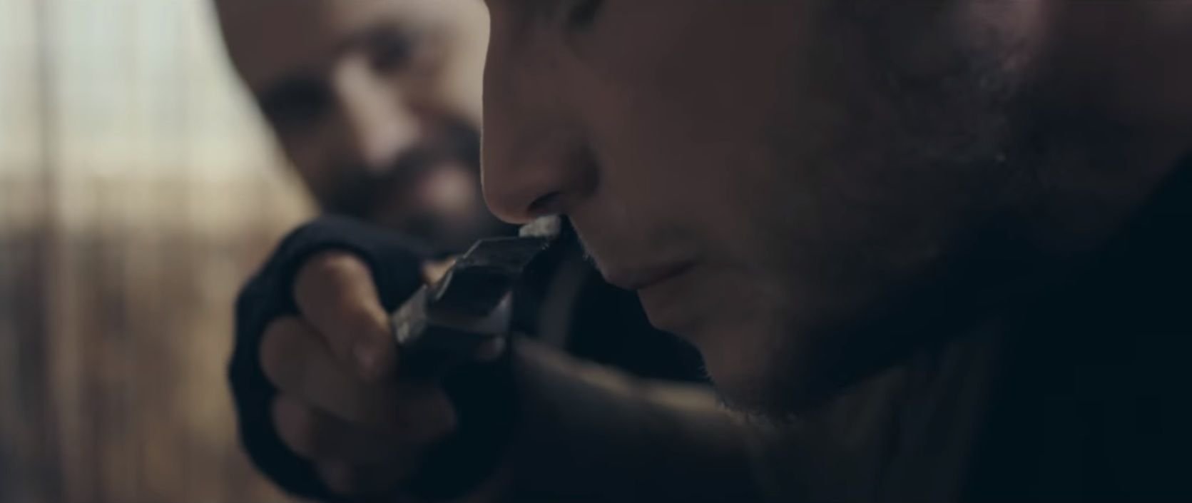 Einer der Darsteller im Goitzschefront-Video zieht sich weißes Pulver durch die Nase.