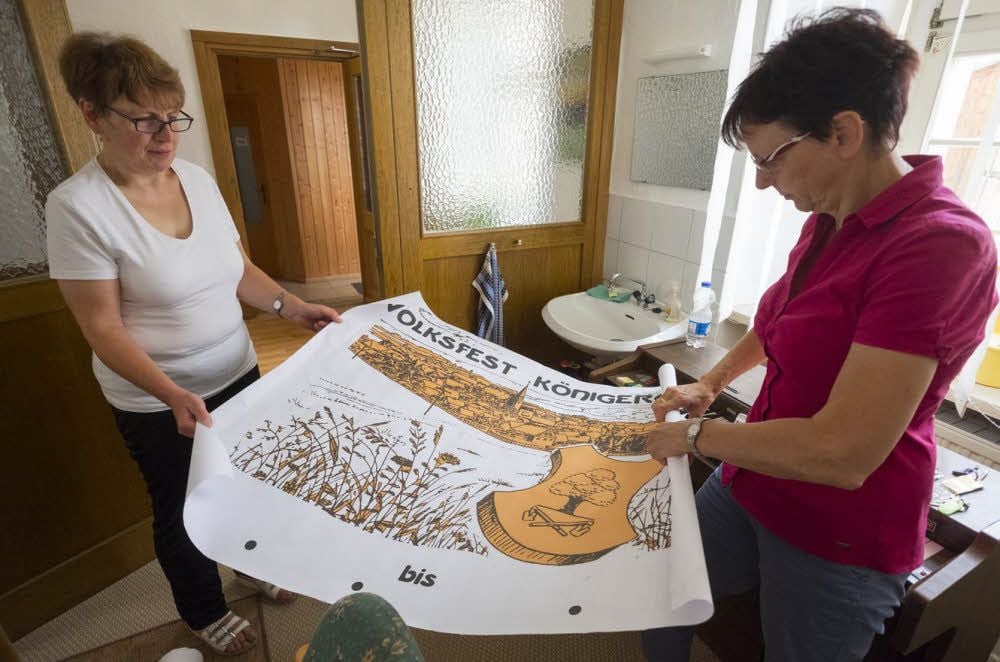 Carmen Dittmann und Viola Kautz (r.) mit einem der großen Festbanner, die inzwischen überall hängen.