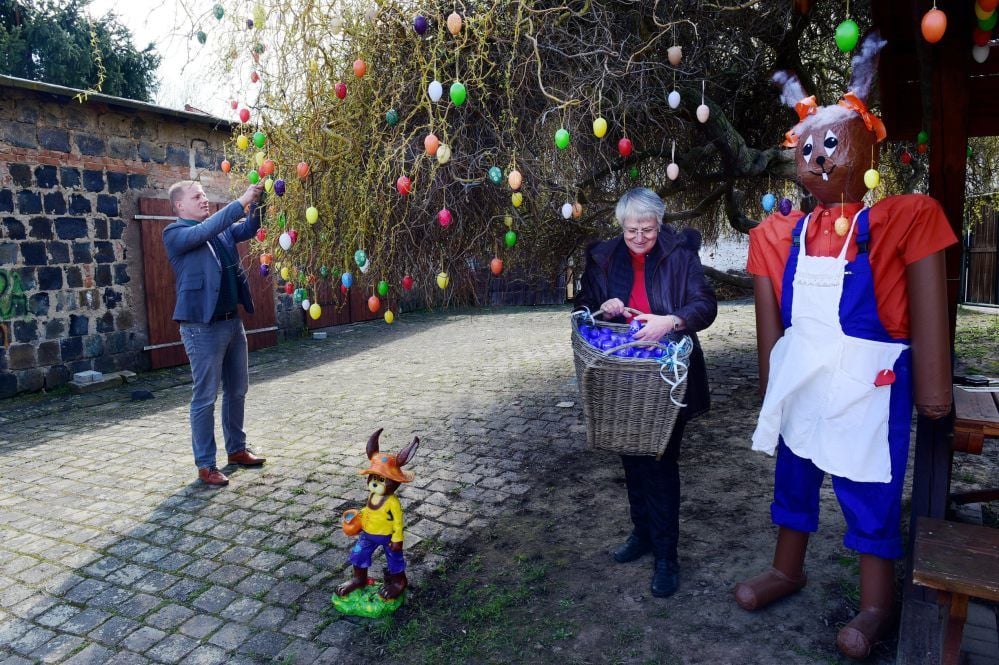 Eisleben: Carsten Staub (links) und Oberbürgermeisterin Jutta Fischer hängen die ersten Eier an den Osterbaum.