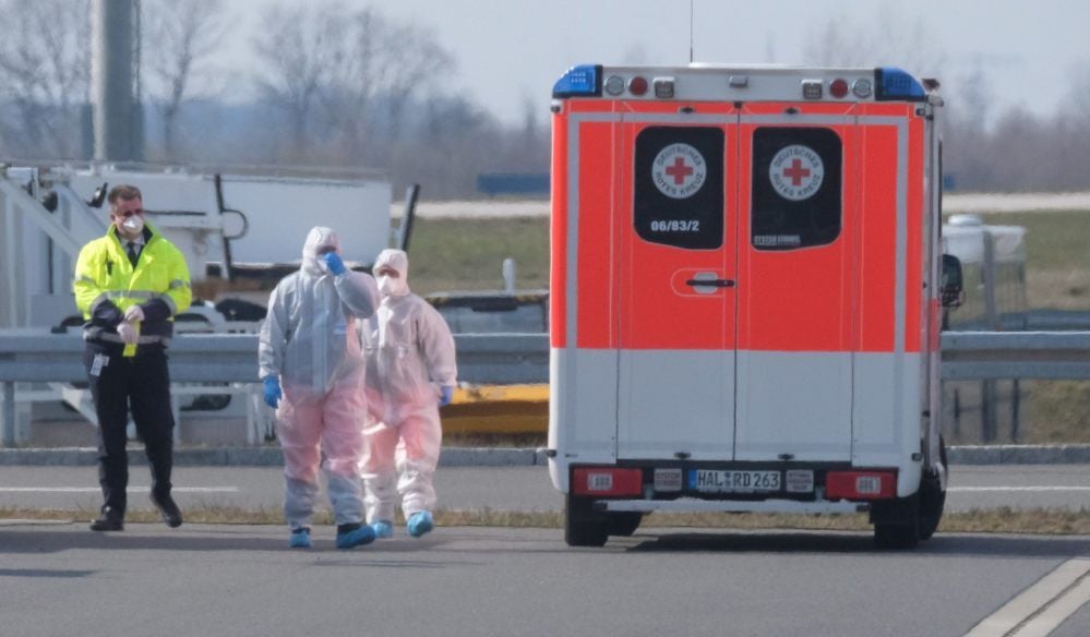 Sanitäter stehen auf dem Flughafen Leipzig-Halle. Dort sind am Donnerstag Corona-Patienten aus dem italienischen Bergamo angekommen.