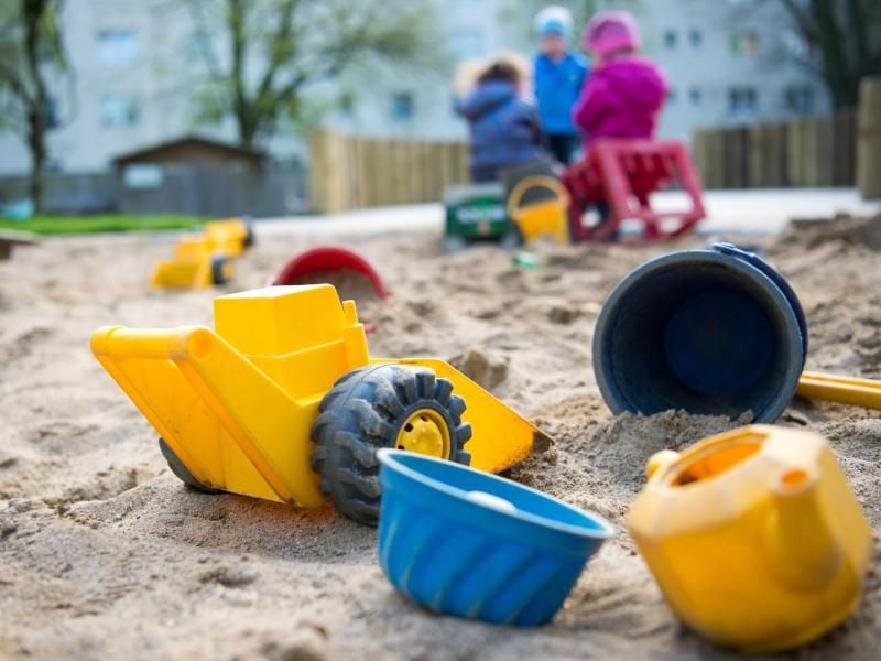 Spielzeug liegt in einem Sandkasten in einer Kindertagesstätte. Foto: Monika Skolimowska/Archiv