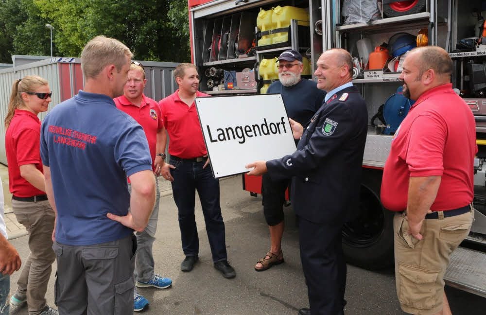 Die Langendorfer Feuerwehr aus der Schweiz (in Rot) hat den Langendorfer Kameraden in Deutschland in kleines Andenken mitgebracht.
