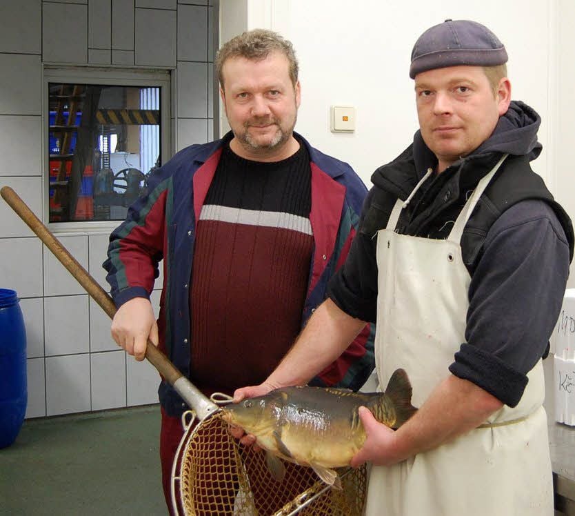 Die Silvestermahlzeit aus den Händen von Frank Ehrmann (links) und seinem Fischwirtschaftsmeister Cornell Lock.