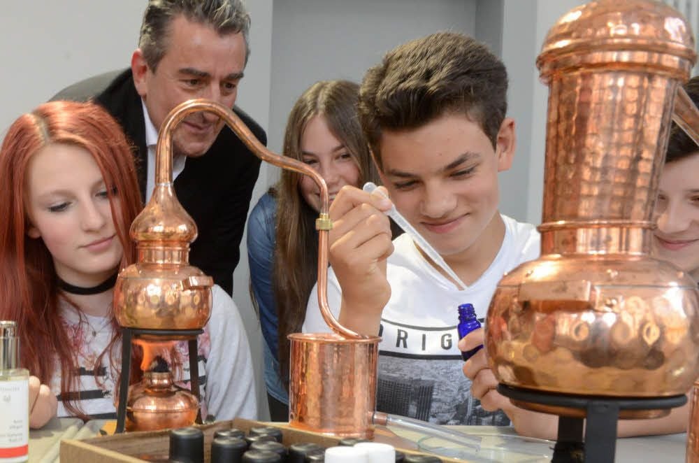 Staatssekretär Gunnar Schellenberger verfolgt gespannt das Experiment, das Tabea, Lara, Sören und Felix (v. l.) in den neuen Räumen durchführen.