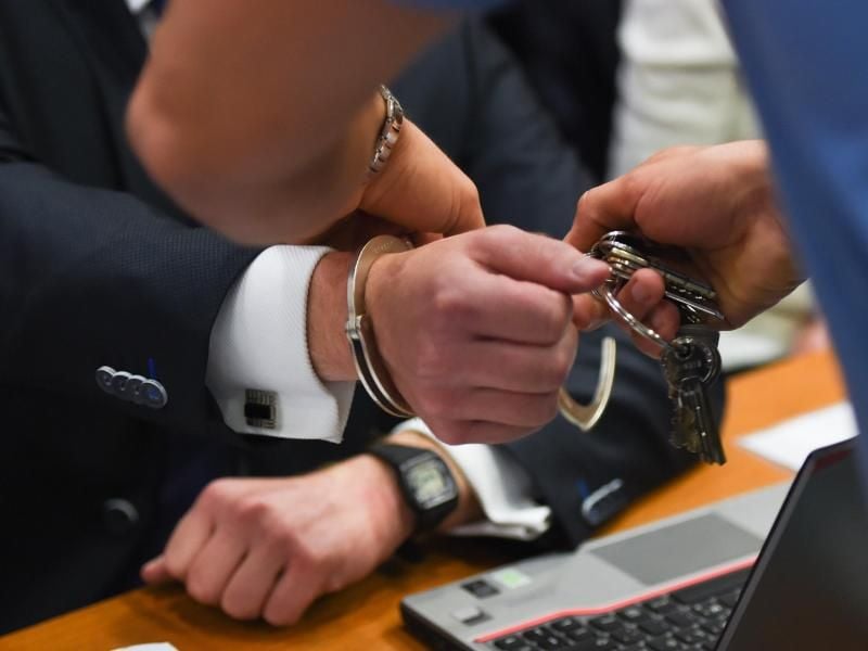 Einem der Angeklagten werden im Landgericht die Handschellen abgenommen. Foto: Arne Dedert/Archiv