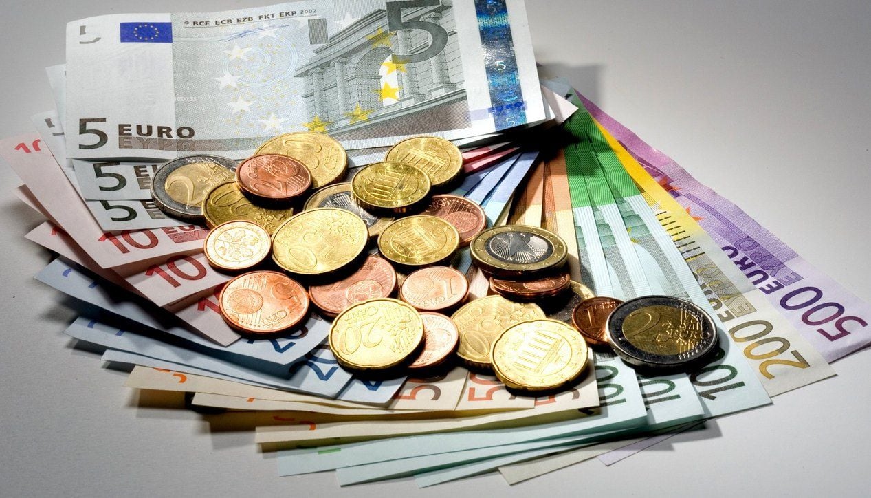 Euromünzen auf einem Fächer aus verschiedenen Euroscheinen