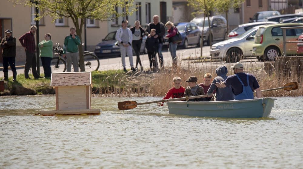 Mit Unterstützung des Angelvereins wird das neue Entenhaus zu seinem Platz mitten auf dem Hagenteich gebracht.