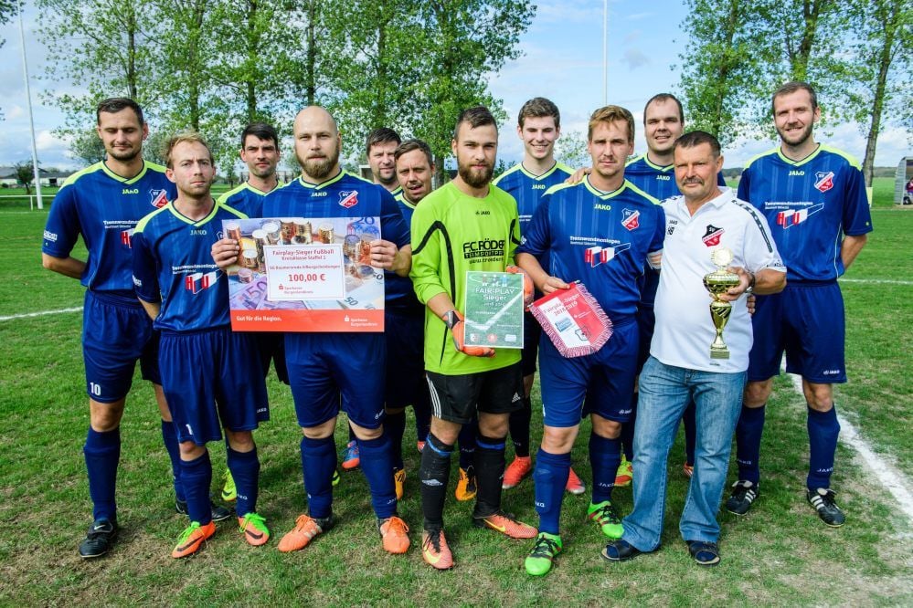 Michael Adamski (mit Scheck), Torwart Tim Walter, Kapitän Matthias Blanke und Coach Heiko Böttcher mit ihren Teamkollegen von der Kombination Baumersroda II/Burgscheidungen.