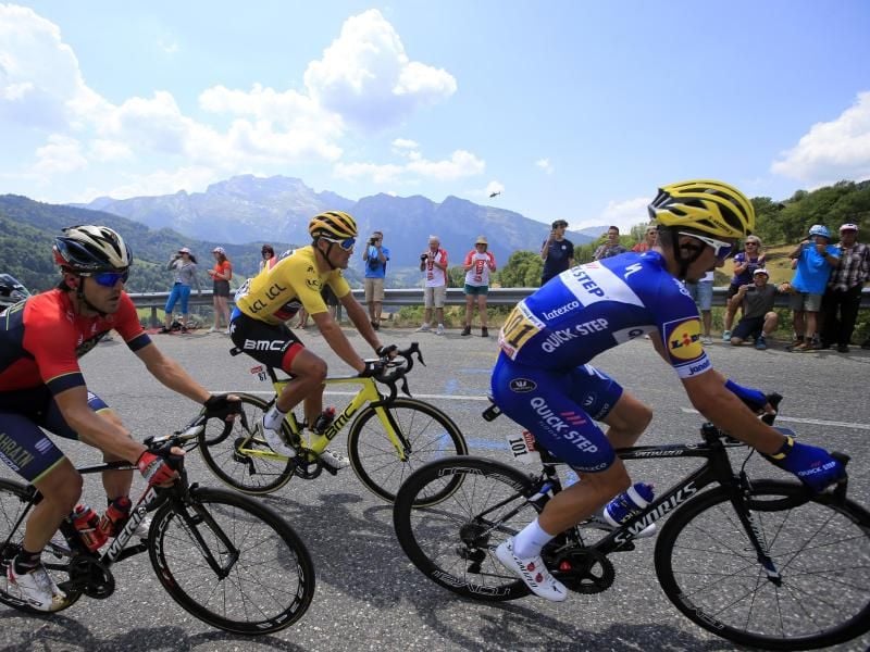 Greg Van Avermaet (M) im Gelben Trikot fährt beim Aufstieg auf den Col de la Croix Fry Bergpass hinter Julian Alaphilippe (r). Foto: Peter Dejong/AP