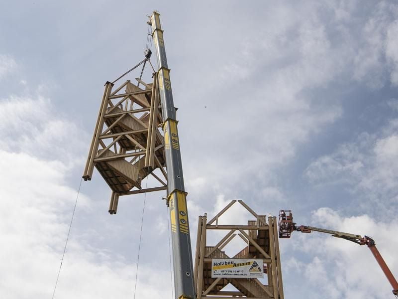 Ein Kran setzt ein Holzmodul auf. Foto: Boris Roessler/dpa