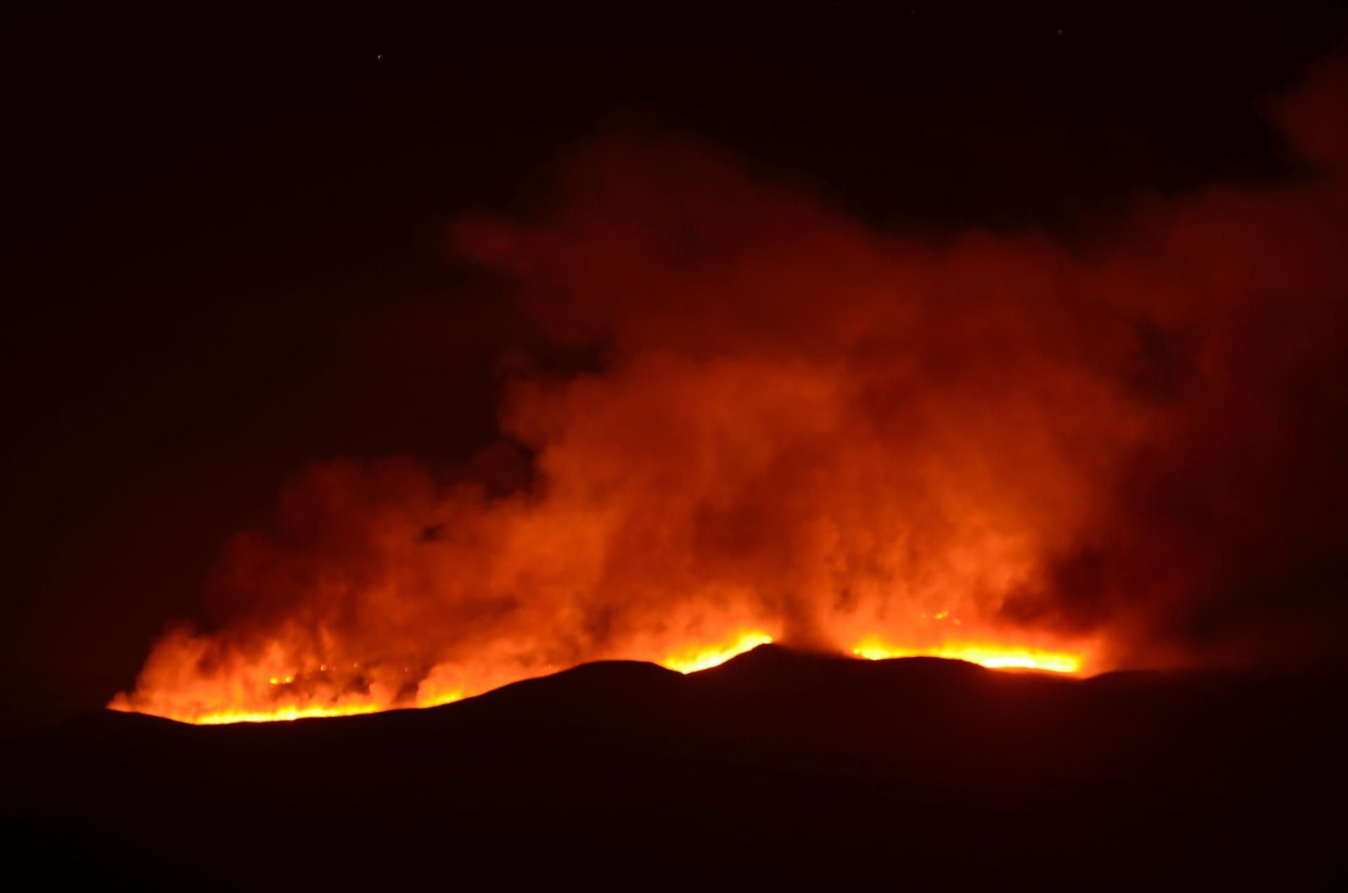 Hell scheinen die Flammen eines Feuers auf dem Kilimandscharo.