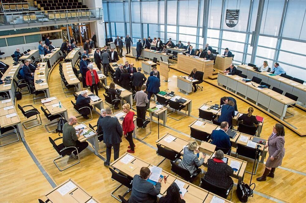 Abgeordnete vor einer Sitzung im Plenarsaal des Landtages von Sachsen-Anhalt.