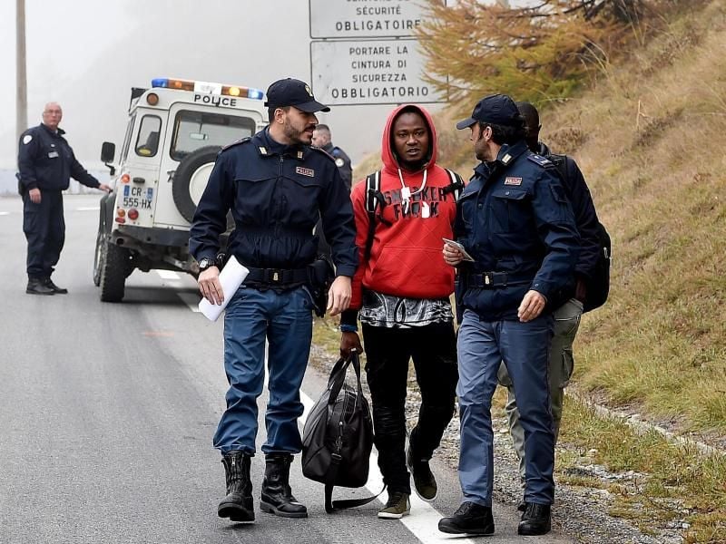 Italienische Polizisten überprüfen einen Mann nahe der Grenze zu Frankreich. Foto: Alessandro Di Marco/ANSA/AP