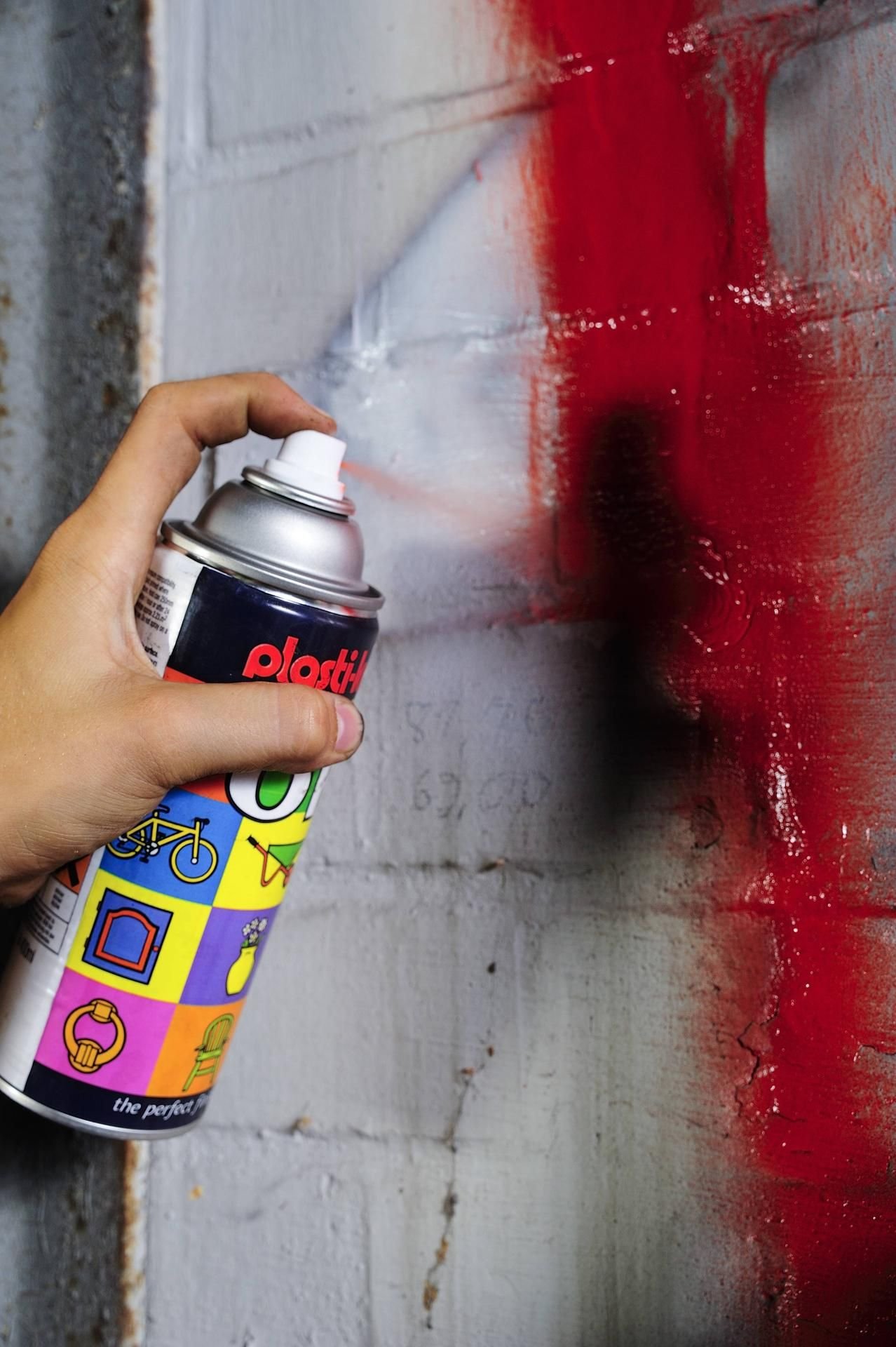 Eine Farbspraydose neben einem Graffiti.
