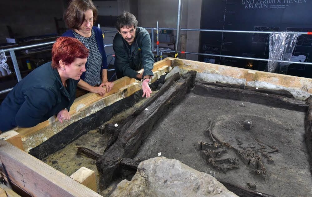 Christina Viol, Saskia Kretschmer und Harald Stäuble (v. l.) begutachten den Ausgrabungsfortschritt. Rechts ist das Tierskelett zu sehen.