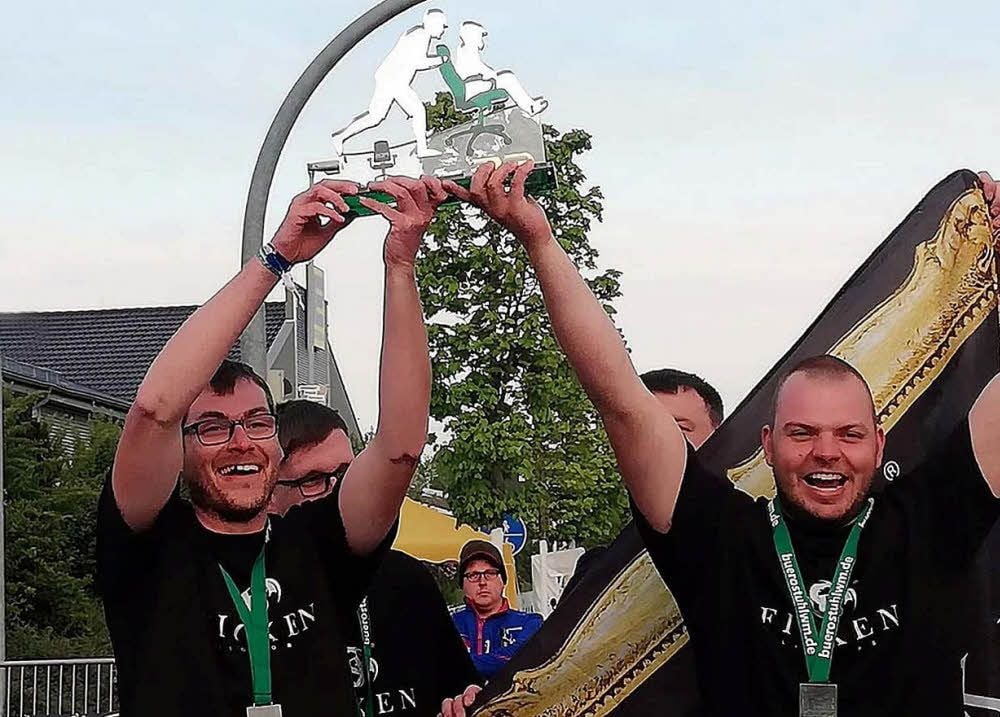 Bei der Siegerehrung mit Pokal: Felix Berthold, Chris Lietzau, Denis Müller und Richard Maaß (von links nach rechts) freuen sich über ihren dritten Platz bei der Bürostuhl-Weltmeisterschaft.