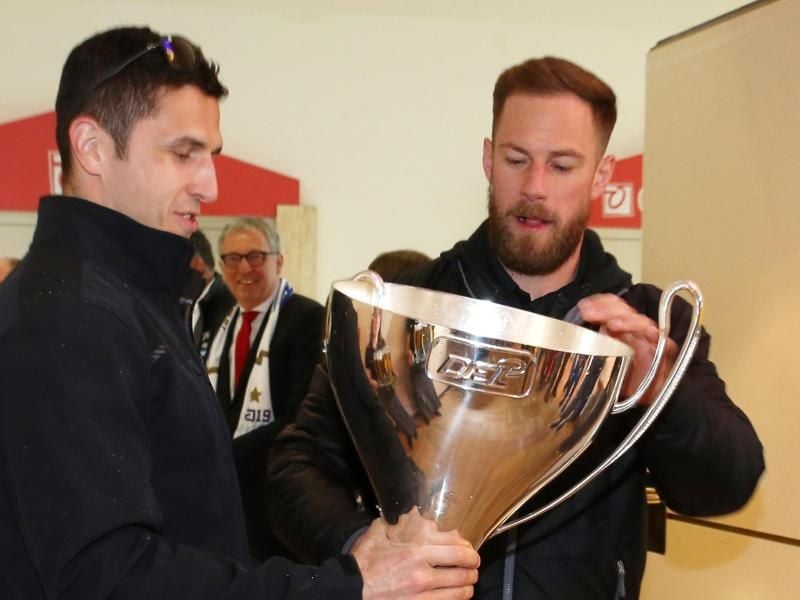 Marcel Goc (l) und Markus Kink begutachten den beschädigten Pokal. Foto: Michael Deines
