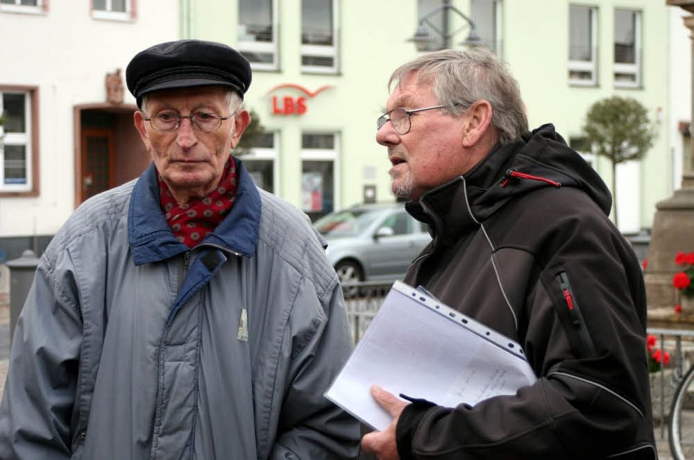 Hans Richter (rechts) von der IG Todesmärsche auf Jessens Markt im Gespräch mit Hans Kampfhenkel, Zeitzeuge für die Häftlingsübernachtung in der Kirche.