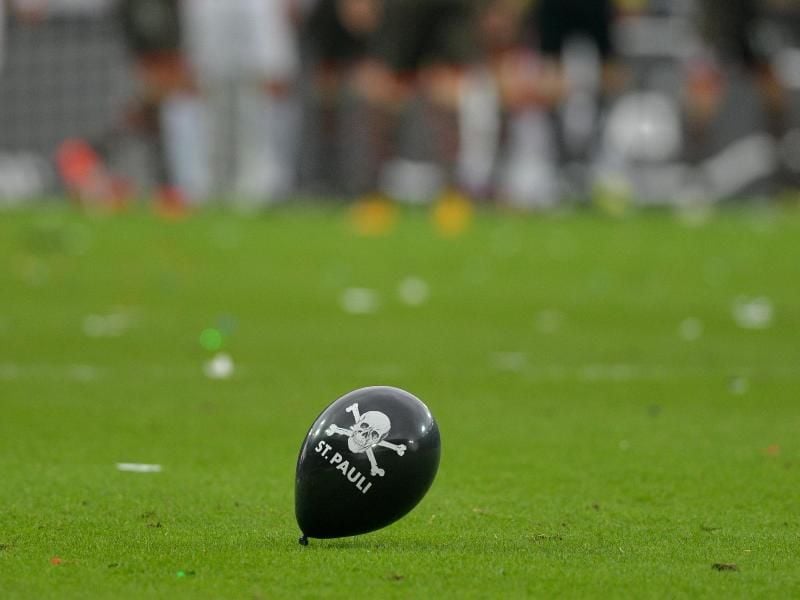 Ein Luftballon mit St. Pauli-Logo weht über das Spielfeld. Foto: Axel Heimken/dpa