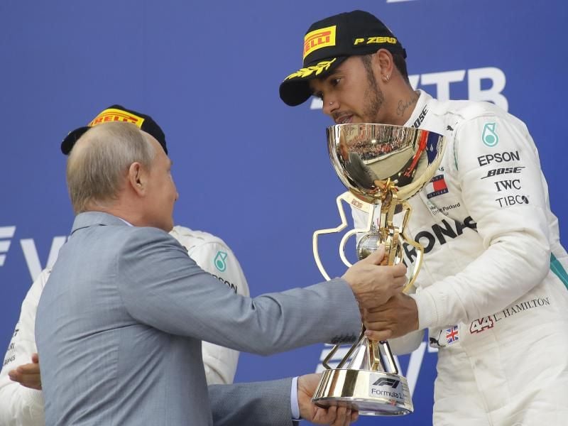 Sieger Lewis Hamilton (r) bekommt von Russlands Präsident Wladimir Putin die Sieger-Trophäe überreicht. Foto: Sergei Grits/AP