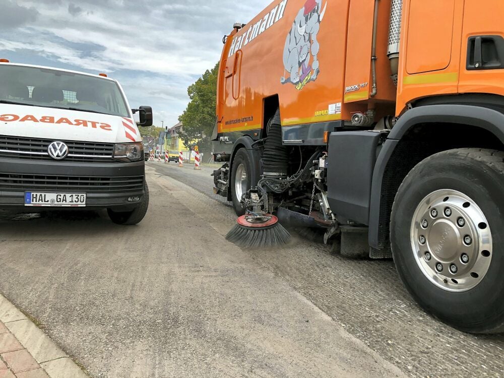 Um für die neue Asphaltschicht einen möglichst sauberen Untergrund zu haben, werden die letzten Reste der abgefrästen Deckschicht weggekehrt.
