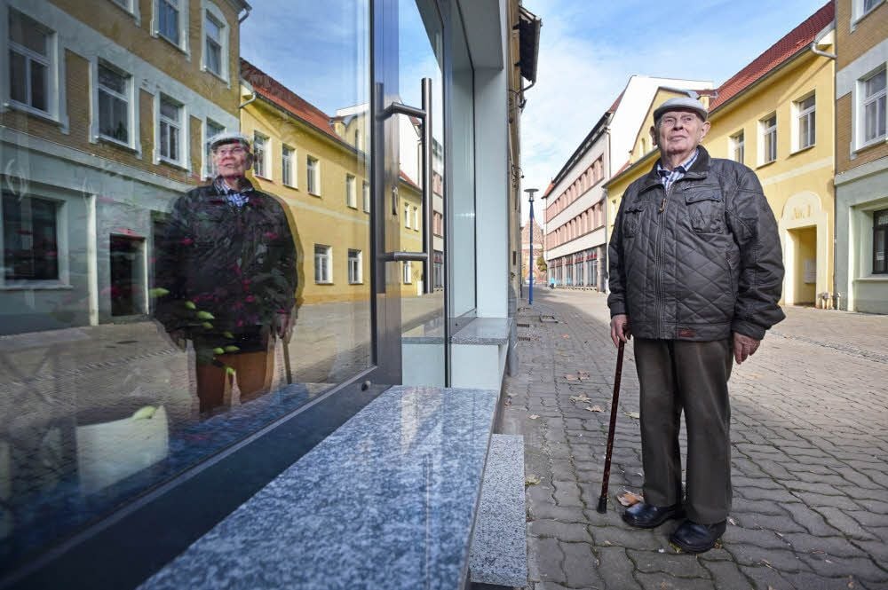Der Bitterfelder Heimatforscher Kurz Menzel steht vor einem Gebäude in der Bitterfelder Kirchstraße, das vor 80 Jahren ebenfalls beschädigt wurde.