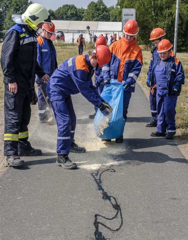 Zum Berufsfeuerwehrtag der Jugendfeuerwehren der Stadt Gräfenhainichen war eine der Aufgaben, eine Ölspur zu beseitigen. Die Kinder nahmen Hobelspäne zum Abbinden. Es ging Hand in Hand.
