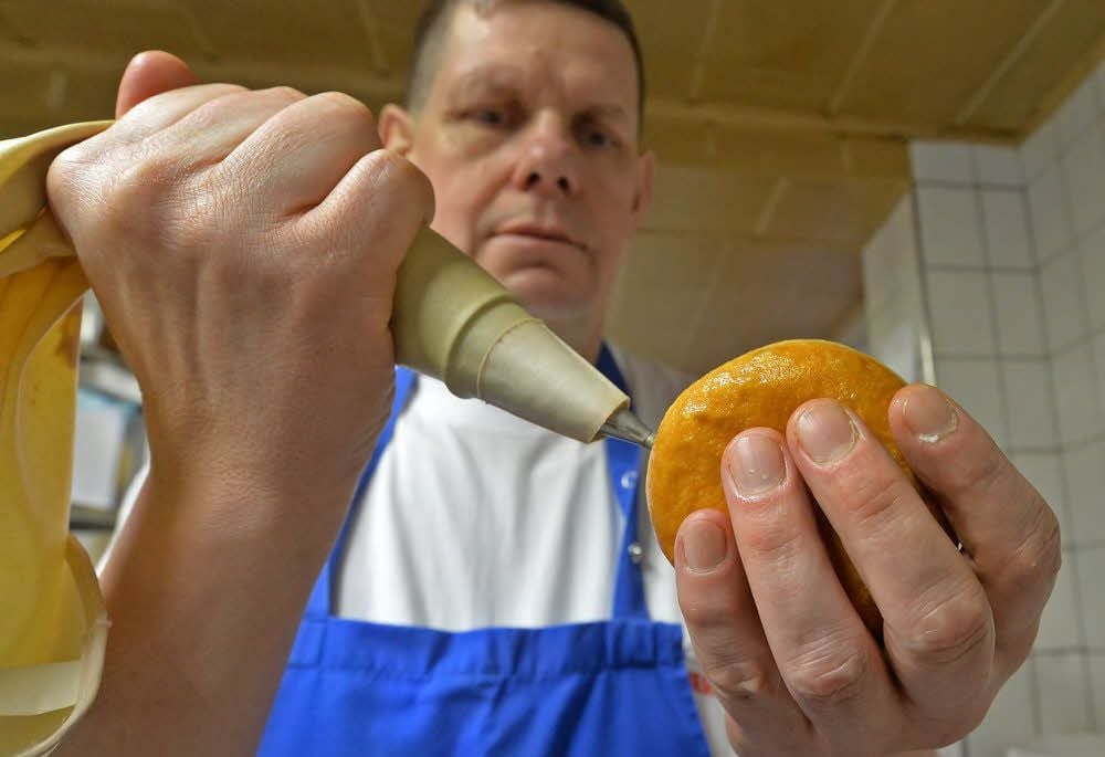 Bäckermeister Sven Kattner präpariert einen Pfannkuchen mit Senf. Ein Faschingsscherz, den die Froser Bäckerei pflegt.
