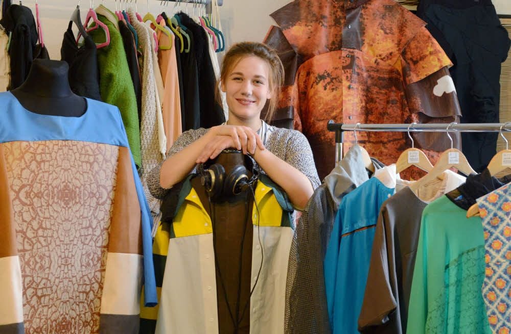 Anna Zeitler mit ihrer Master-Abschlusskollektion „Boomerang – Alles kommt zurück“, die negative Auswirkungen der Massenproduktion von Textilien aufgreift: Zum Beispiel Bodenerosion (Modell links) oder einen Fabrikbrand (Modell hinten).