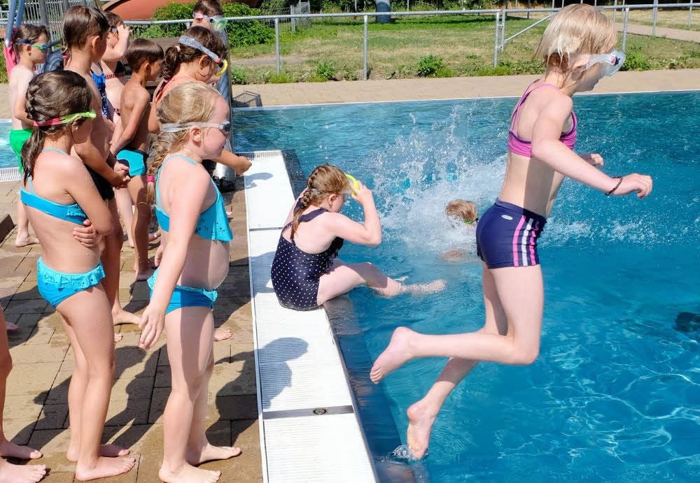 Die Kinder der Gruppe von Klaus-Dieter Richter haben keine Angst vorm Sprung ins Wasser. Nach einer kurzen Tauchphase geht es zurück zum Beckenrand. Insgesamt 75 Zweitklässler der Grundschule „Max Lingner“ Jessen nehmen am Schwimmlager im Familienbad Oehna teil.
