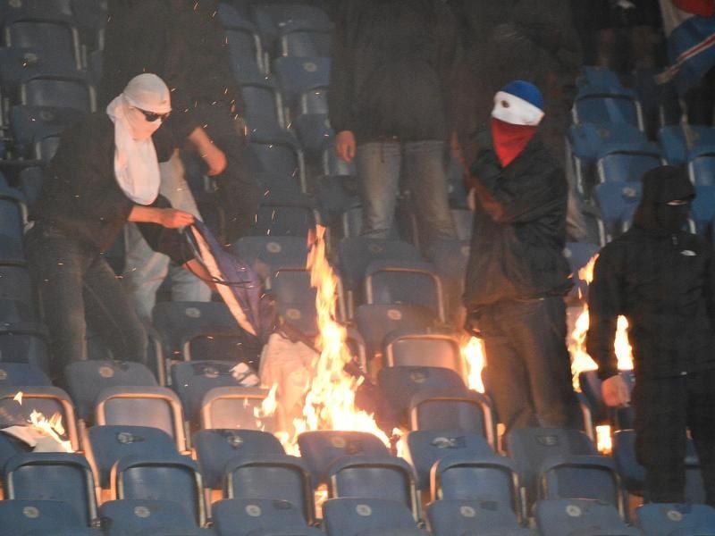 Anhänger von Hansa Rostock verbrennen Fahnen von Hertha BSC. Foto: Axel Heimken