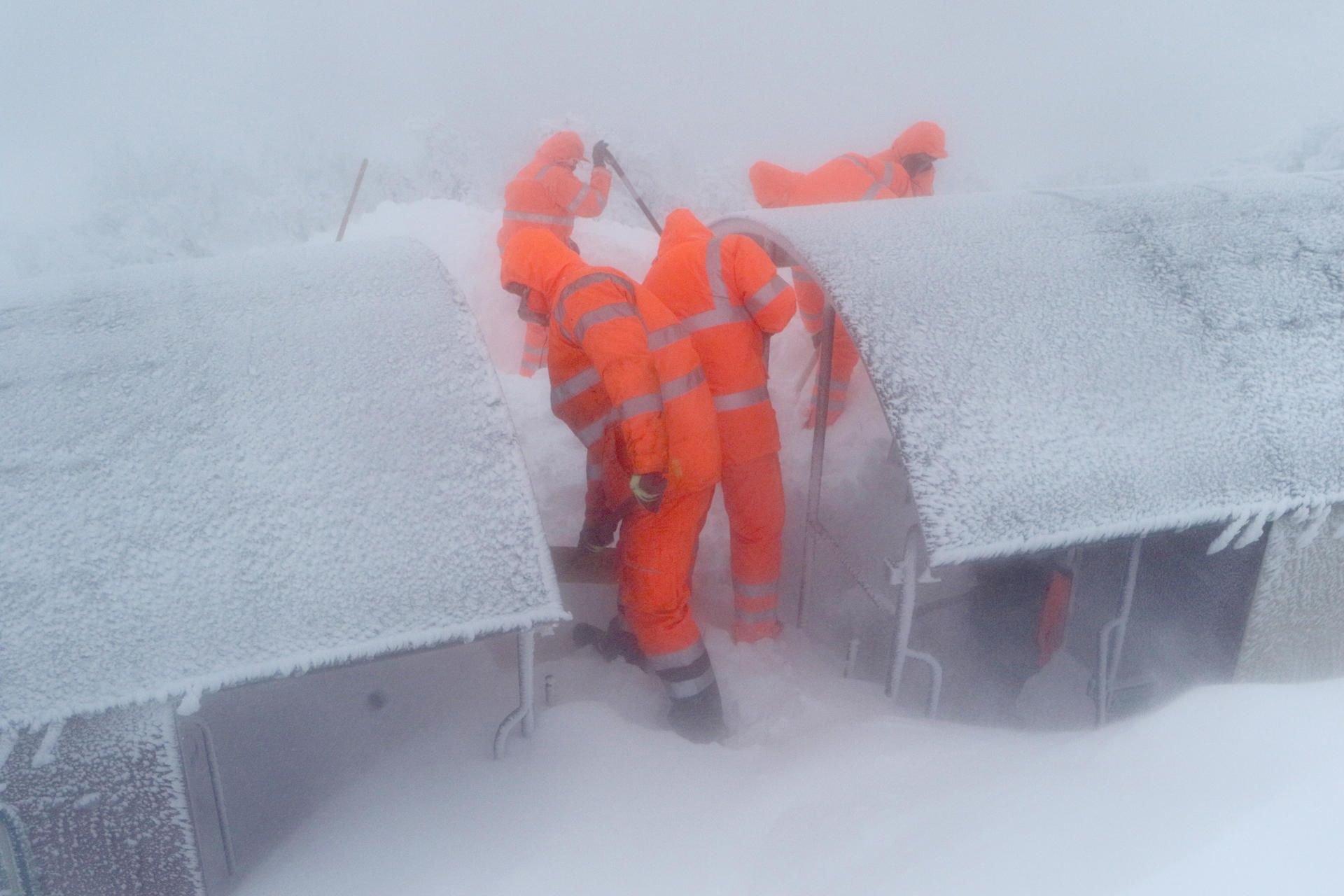 Mitarbeiter der Servicegesellschaft versuchen einen Zug der Harzer Schmalspurbahn, der seit Montag auf dem Brocken eingeschneit ist, vom Schnee zu befreien.