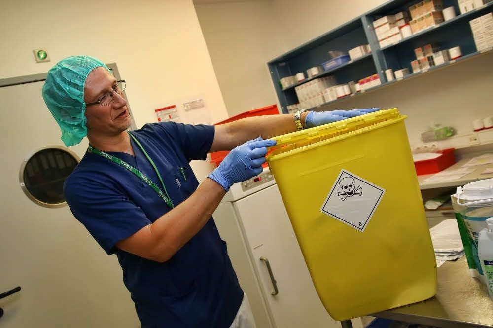 Apotheker Christian Augsten zeigt die Spezialabfalltonne, in der die Zytostaktikareste entsorgt werden.