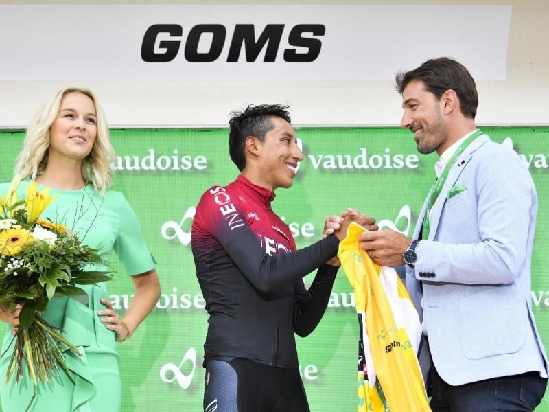 Egan Bernal (M) aus Kolumbien vom Team Ineos erhält das gelbe Trikot. Bernal führt in der Gesamtwertung. Foto: Gian Ehrenzeller/KEYSTONE