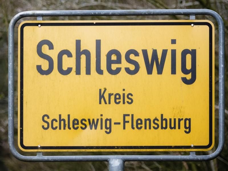 Das Ortsschild der Stadt Schleswig ist zu sehen. Foto: Markus Scholz/Archivbild
