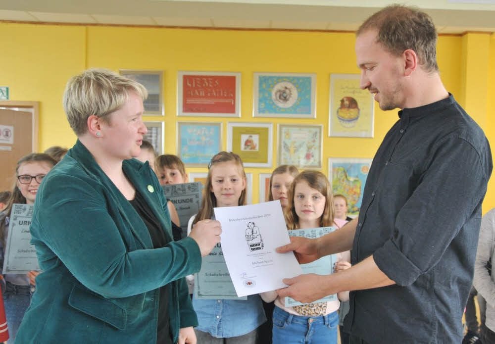 Sandra Heuchel, Geschäftsführerin des Bödecker-Kreises, ernennt Michael Spyra, Autor aus Halle, zum nächsten Oberschulschreiber.