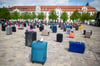 Koffer unterschiedlicher Form, Größe und Farbe stehen auf dem Domplatz Magdeburg: Eine Mahnwache und Kundgebungen machen auf die aktuell schwierige Situation in der Reisebranche aufmerksam.