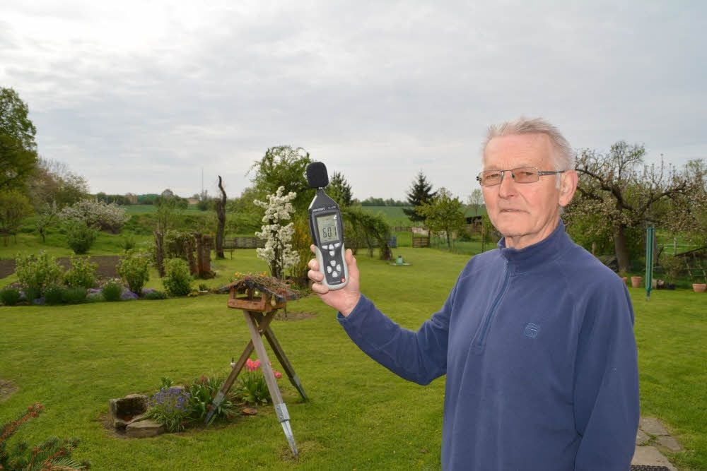 Gerd Nowozin in seinem Garten. Das Lärmmessgerät zeigt schon am frühen Vormittag 60 Dezibel an.