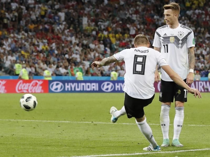Toni Kroos (l) hat den Freistoß kurz ausgeführt und erzielt nach der Rückgabe von Marco Reus (r) das Tor zum 2:1-Endstand gegen Schweden. Foto: Frank Augstein/AP