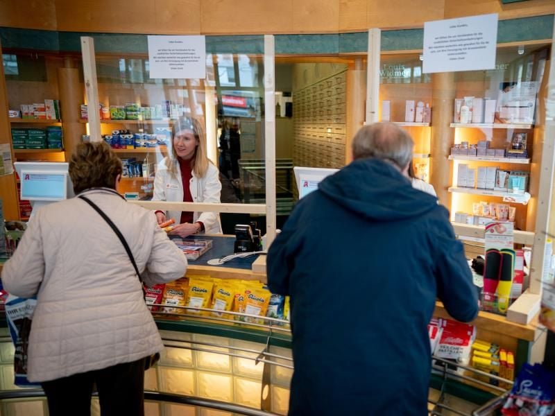 Eine Apothekerin bedient zum Schutz vor dem Coronavirus hinter einer Plexiglasscheibe. Foto: Kay Nietfeld/dpa/Archivbild