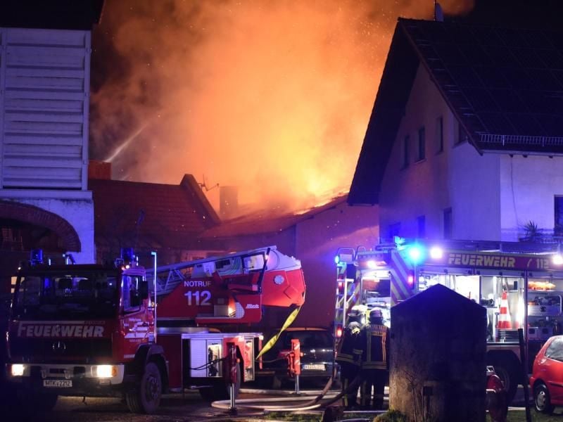 Einsatzkräfte der Feuerwehr löschen einen Brand mehrerer Gebäuden bei Hofheim. Foto: Jürgen Mahnke